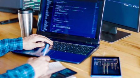 Multiple,Computer,Screens,With,Program,Code,On,Office,Table.,Programmer,